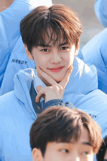 a boy wearing a blue jacket with the word nerdy on the front