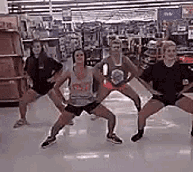 a group of women are dancing together in a grocery store .