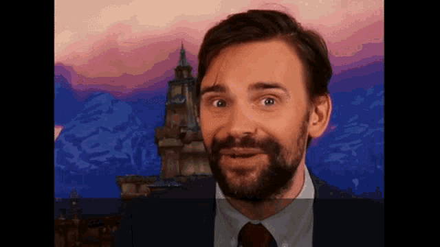 a man with a beard wearing a suit and tie looks surprised
