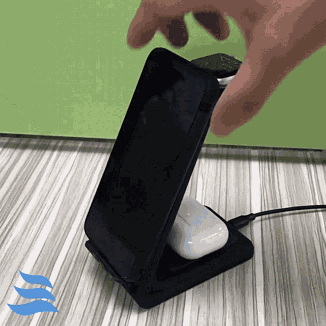 a phone sitting on top of a charging dock with a watch and airpods on it