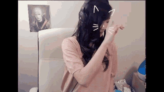 a woman wearing headphones has a cat face drawn on her hair ..