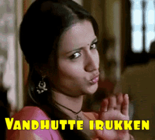 a woman is making a funny face with the words vandhutte iruken written above her
