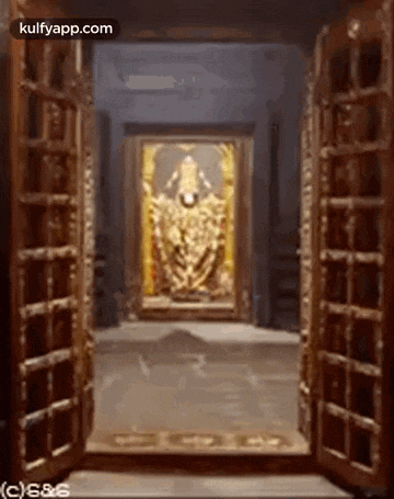 a door is open to a room with a painting of a deity in the corner .