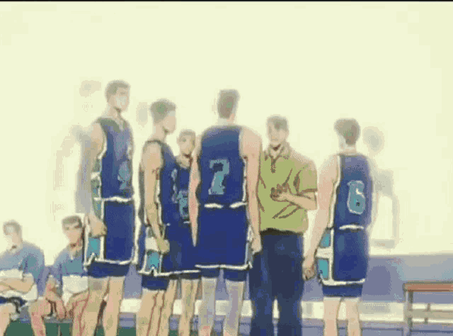 a group of basketball players are standing next to each other on a court talking to each other .