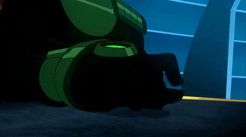 a cartoon character wearing a mask and a green suit is sitting in a chair