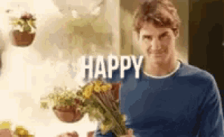 a man is holding a bouquet of flowers and says happy .