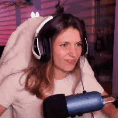 a woman wearing headphones and a blue microphone is sitting in front of a microphone .