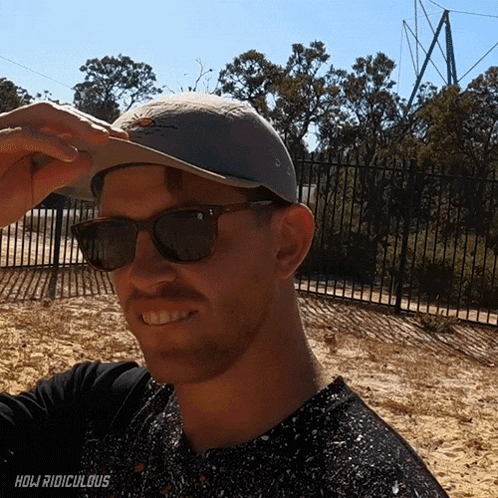 a man wearing sunglasses and a hat with the word ridiculous on the bottom