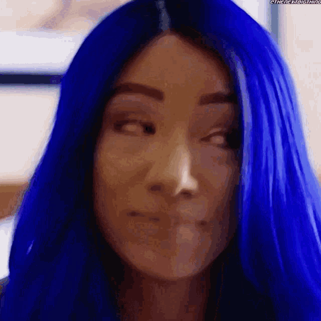 a close up of a woman 's face with blue hair