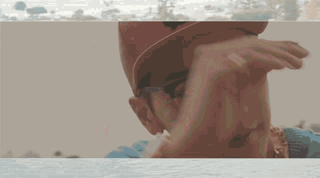 a man wearing a red hat and sunglasses is covering his face