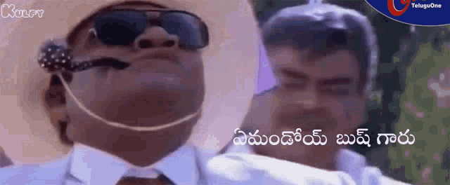 a man wearing sunglasses and a hat is talking to another man in a foreign language