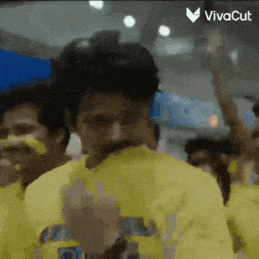 a man wearing a yellow shirt with the word vivacut on the bottom