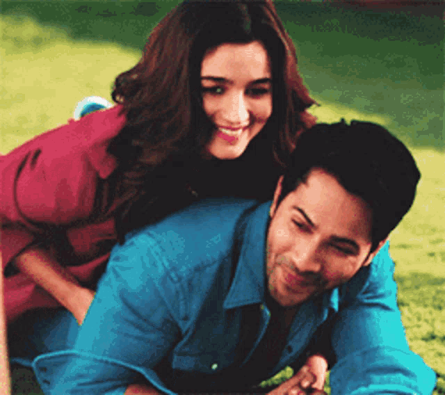a man is giving a woman a piggyback ride in the grass