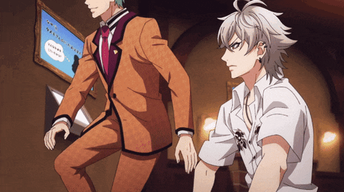a man in an orange suit is standing next to another man