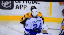 a hockey player with the number 24 on his jersey is fighting another player