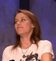 a woman wearing a white shirt and a necklace is looking up .