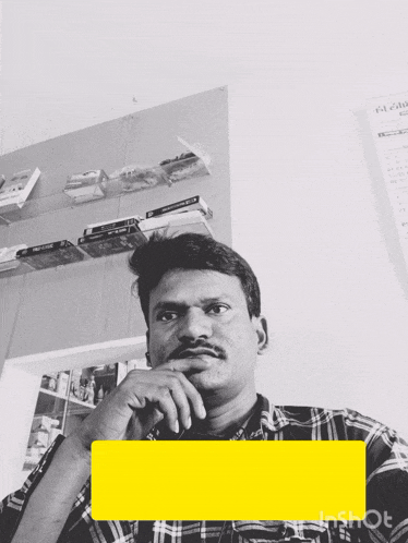 a man in a plaid shirt is looking at the camera with a calendar behind him that says december