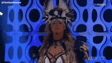 a woman in a feathered costume is standing in front of a blue wall .