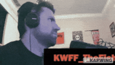 a man wearing headphones is looking at a sign that says kawff