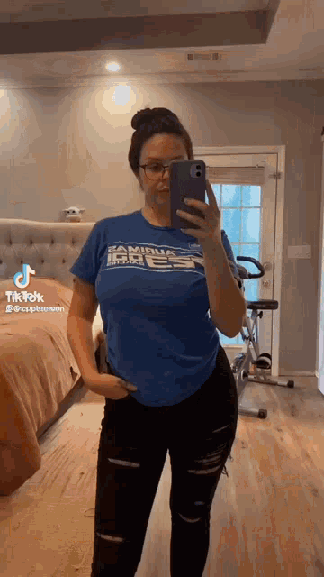 a woman is taking a selfie with her phone in a room .