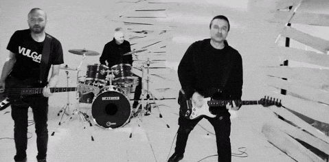 a black and white photo of a man playing drums .