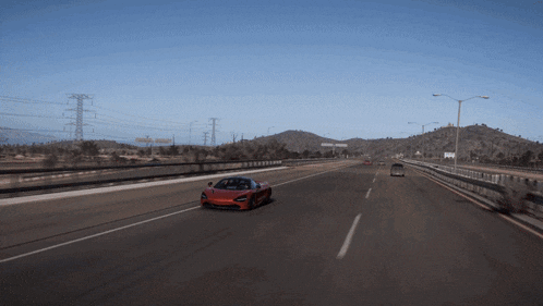 a red sports car is driving on a highway