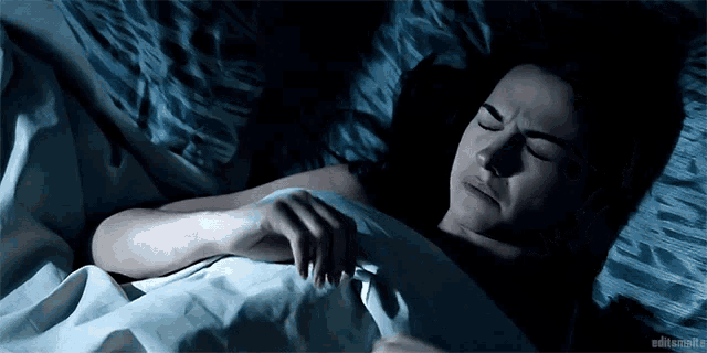 a woman is laying in bed with her eyes closed and a caption that says editsmails