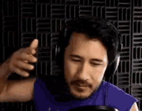 a man is wearing headphones and giving a thumbs up .