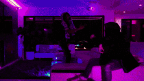 a person is sitting on a couch in a living room with green lights