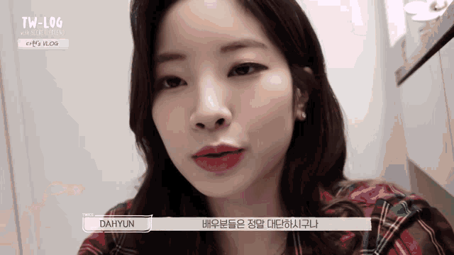 a close up of a woman wearing a plaid shirt with the name dahyun on the bottom