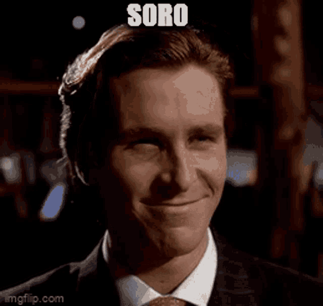 a man in a suit and tie is smiling and making a funny face with the word soro above him .