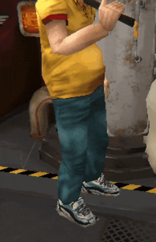 a man in a yellow shirt and blue jeans is standing in front of a metal pipe