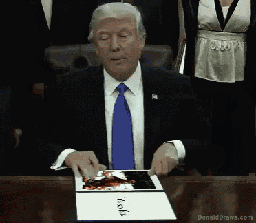 a man in a suit and tie is sitting at a table holding a piece of paper that says it 's so fine