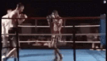 a blurry picture of two men boxing in a boxing ring