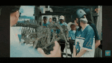 a person wearing a jersey with the letter a on it stands in front of a dinosaur skeleton