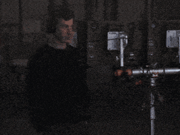 a man wearing headphones stands in front of a computer monitor
