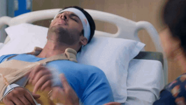 a man in a hospital bed has a bandage on his head