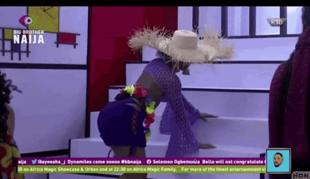 a woman wearing a straw hat is standing on a staircase in front of a big brother naija logo