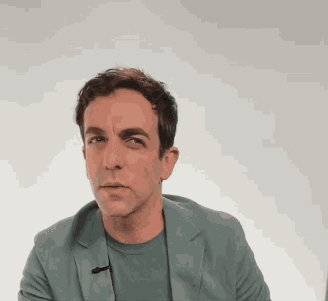 a man in a suit and a t-shirt with a microphone on his neck