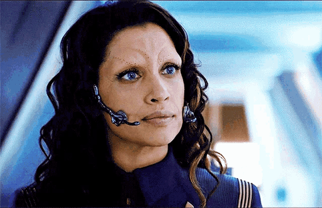 a woman with a headset on looks at the camera