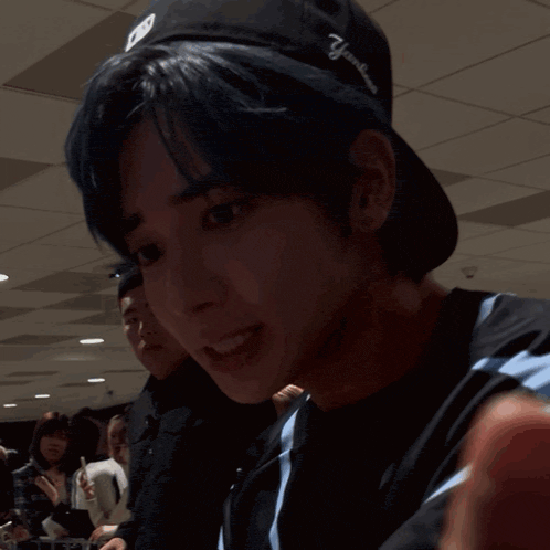 a man with blue hair is making a funny face while holding a pen