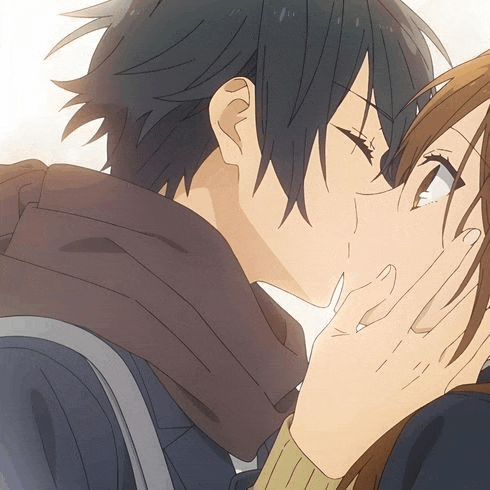 a boy and a girl are kissing in a close up of their faces .