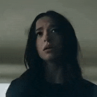 a close up of a woman 's face in a dark room looking up .