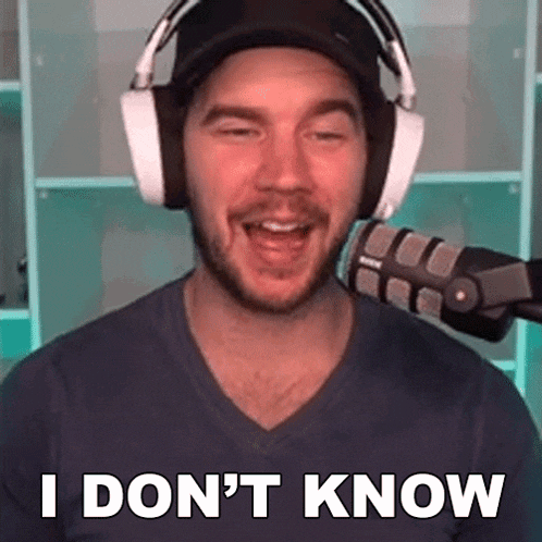 a man wearing headphones and a hat is talking into a microphone and saying `` i don 't know ''