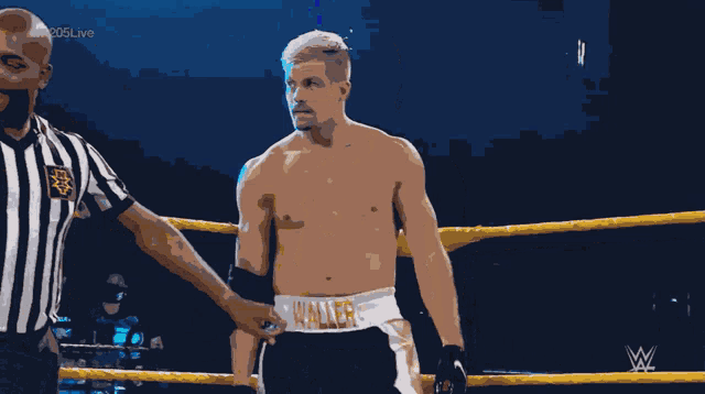 a referee talks to a wrestler in a boxing ring whose shorts say keller