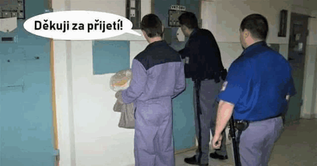 a group of police officers standing next to a man in a prison cell .