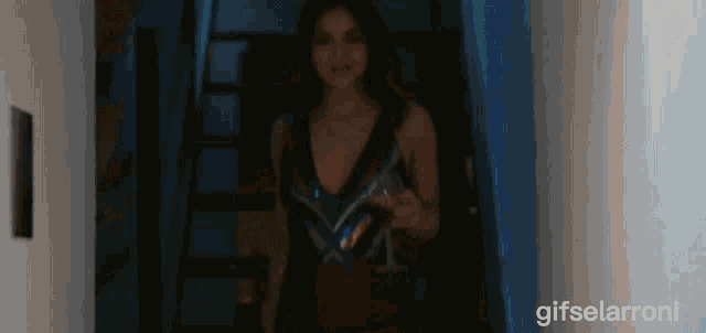 a woman is walking down stairs with a glass of wine in her hand and a gifselarroni watermark in the corner