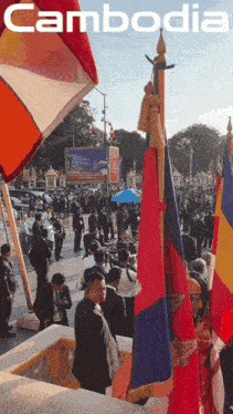 a group of people standing in front of a sign that says " cambodia "
