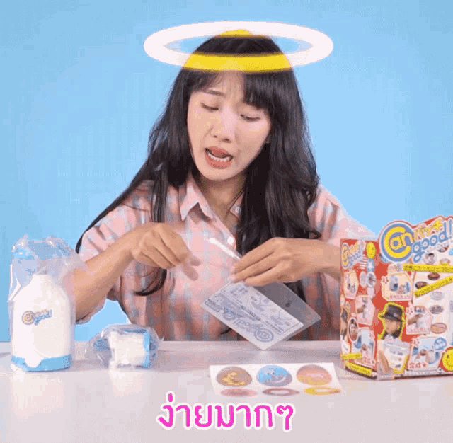 a woman with a halo on her head is playing with a toy that says angel good