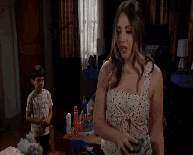 a boy and a girl are playing with toys in a bedroom with a bed that has a tractor on it